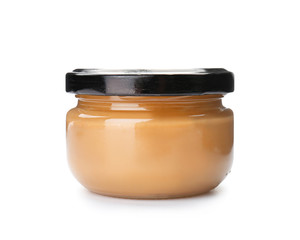 Jar with creamy peanut butter on white background