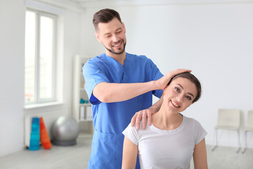 Physiotherapist working with female patient in clinic
