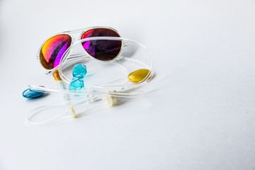 colored sunglasses and medical dropper over white background