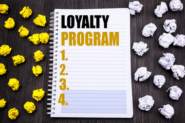 Conceptual hand writing text caption showing Loyalty Program. Business concept for Marketing Concept Written on notepad note notebook book wooden background with sticky folded yellow and white