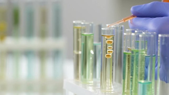 Cosmetology center worker adding essential oil to create concentrate agent