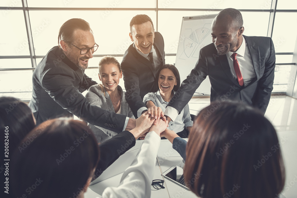 Poster we are team. outgoing partners demonstrating unity while situating at desk. achievement in labor con