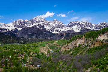 Fototapeta na wymiar View over the town and walnut forests of Arslanbob village in southern Kyrgyzstan, with mountains in the background