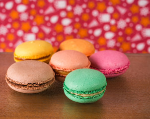 Fototapeta na wymiar Colorful French or Italian macarons stack on wooden background put with copy space for background