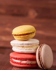 Stack of colorful macaroons on a wooden background