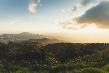 Smoky mountain landscape with mountain and light rays in sunset scene.