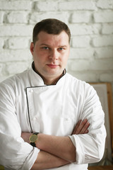 Food and people concept: male chef with cooked food standing in the kitchen.