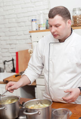 Food and people concept: male chef with cooked food standing in the kitchen.