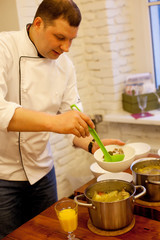 Food and people concept: male chef with cooked food standing in the kitchen.