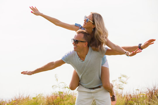 Couple piggybacking outdoors