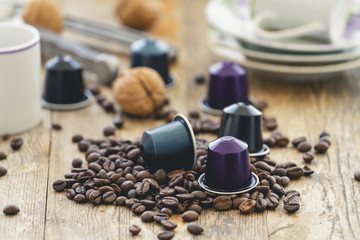 Italian espresso coffee capsules or coffee pods with espresso cups and coffee beans on a rustic...