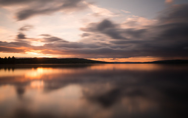 Beautiful sunset over a swedish natural lake photographed with long exposure
