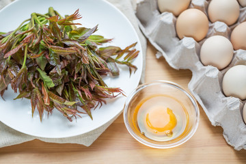 Chinese food, Scrambled Eggs with Toona sinensis,  Preparing food. Fresh Toona sinensis and eggs on table.