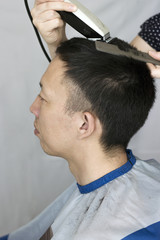 Modern man's haircut with a hair clipper and comb