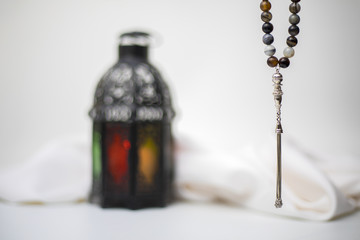 Part of rosary beads in front of blurred lantern in the background