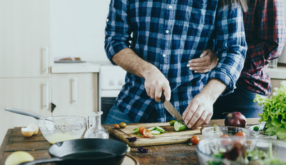 Couple cooking breakfast from vegetables at home in the kitchen
