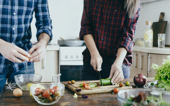 Couple preparing breakfast from vegetables at home in the kitchen