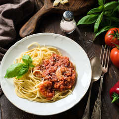 Spaghetti with tomato sauce, shrimps and grated parmesan cheese. Close up view, square crop