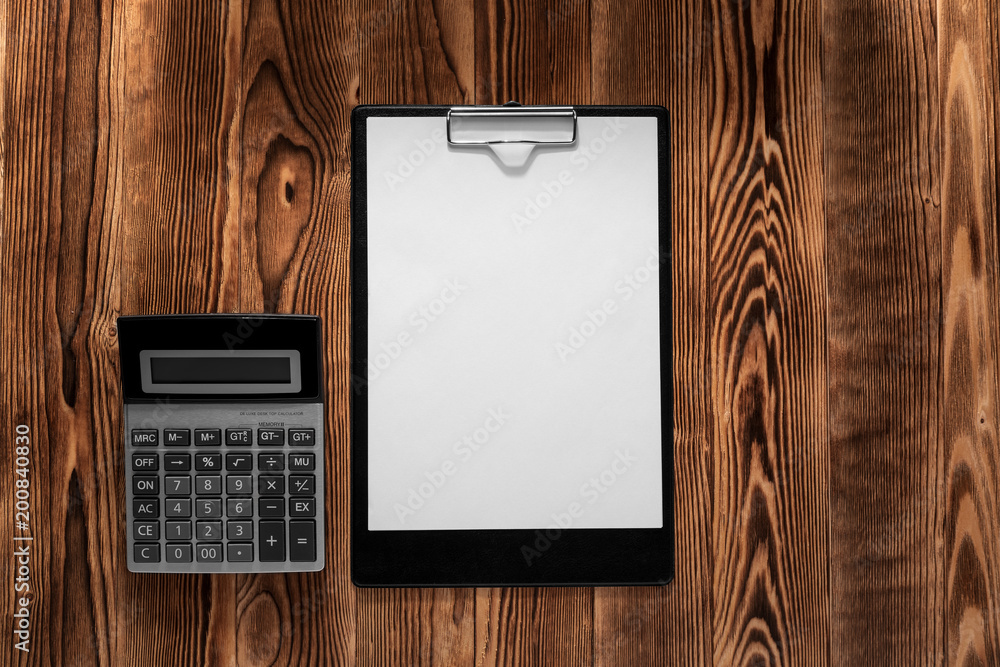 Poster the white open notepad and computer keypad isolated on the wooden desktop