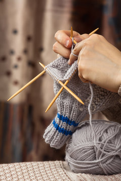 hands of woman knitting a sock with bamboo needles