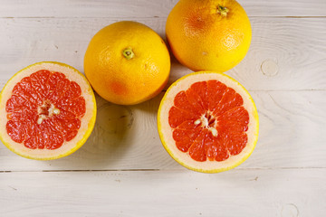 Ripe fresh grapefruits on white wooden table