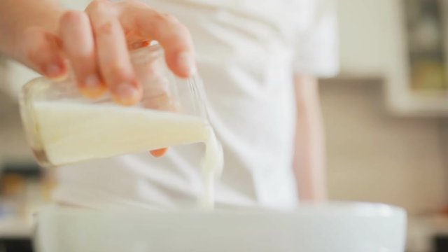 cook pours a Cup of kefir in a Cup