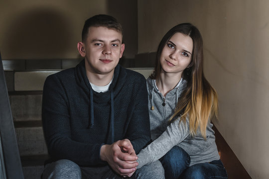 Teenagers boyfriend and girlfriend sit on the steps in block of flats