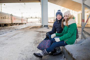 Couple at railway station near train in a winter time