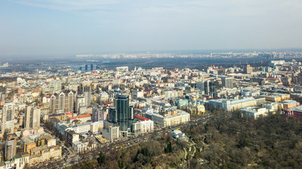 Fototapeta premium City of Kiev on a sunny day. Modern high-rise buildings and a park. Aerial photo from the drone