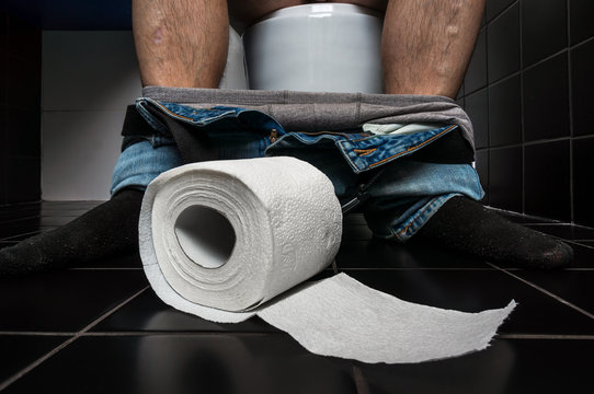 Man suffers from diarrhea is sitting on toilet bowl