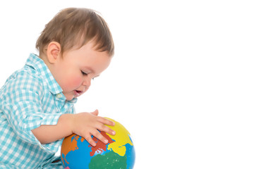 A little boy is playing with a globe.