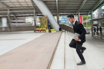 Businessman running in hurry at town