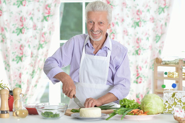 Senior man  preparing dinner in kitchen