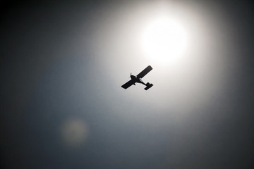 The plane is flying in front of the sun.