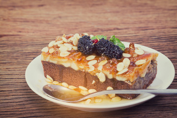 Delicious homemade toffee cake with mulberry on the wooden board.