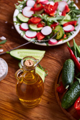 Creative fresh vegetable salad with ruccola, cucumber, tomatoes and raddish on white plate, selective focus