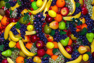 Colofrul background of different fruits - bananas, grapes, apples, oranges