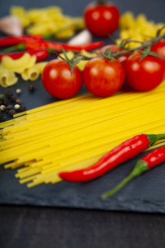 Different pasta on a dark wooden background