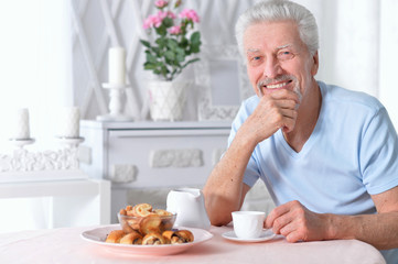 smiling senior man drinking tea at home 