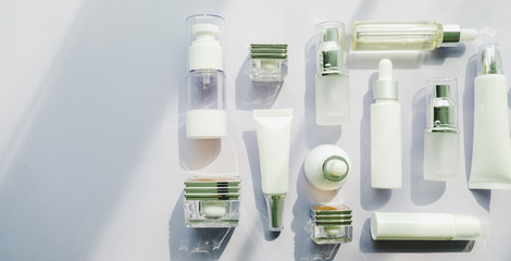 cosmetic packaging set on purple background. group of skincare cream serum oil . facial beauty cosmetic spa product. natural cosmetology concept skin treatment with green leaf and laboratory science 