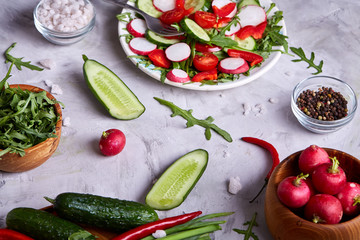 Still life of wooden plate with vegetables on white textured background, close-up, selective focus