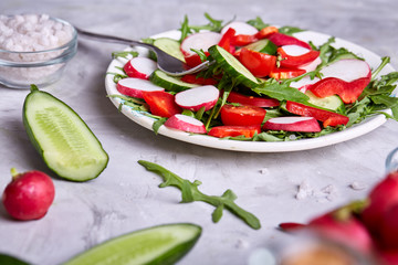 Still life of wooden plate with vegetables on white textured background, close-up, selective focus