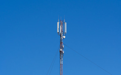 Technology on the top of the telecommunication GSM (4G) tower (antenna, transmitter), blue sky