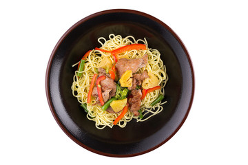 Egg noodles with chicken and pineapple under teriyaki sauce, isolated on white background. Egg noodles in a black plate.