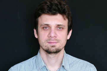 Obraz premium Portrait of young handsome man in plaid short looking at camera.