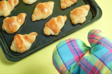 Image to pick up bread from an oven, bake bread in an oven. オーブンからパンを取り出す、パンをオーブンで焼くイメージ　黄色背景