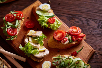 Breakfast sandwich with homemade paste, vegetables and fresh greens, shallow depth of field