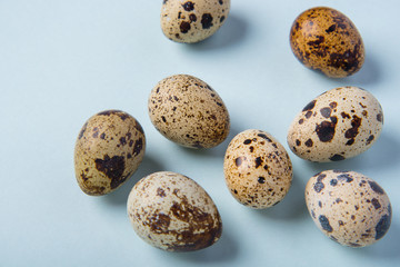 Obraz premium Beautiful spotted fresh quail eggs on a blue paper background