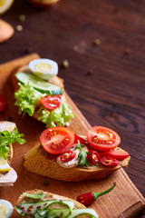 Breakfast sandwich with homemade paste, vegetables and fresh greens, shallow depth of field