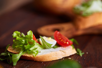 Breakfast sandwich with homemade paste, vegetables and fresh greens, shallow depth of field